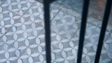 אריחי בטון מוטבעים בגוונים של אפור ולבן ברצפת חצר בבית בהרצליה